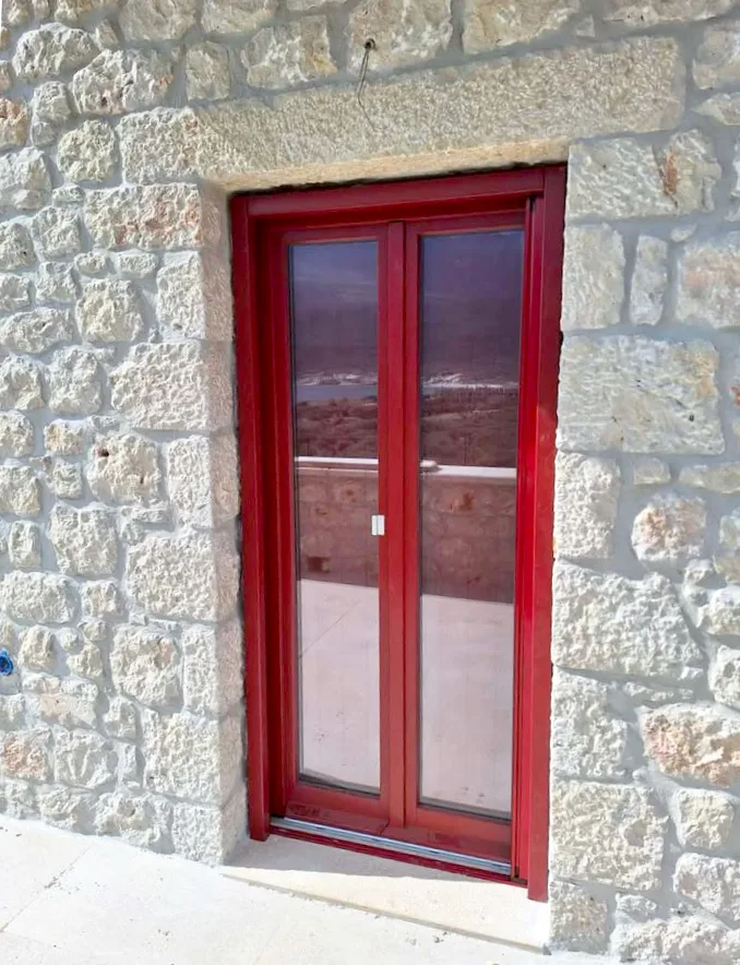 ξύλινα κουφώματα στην Μάνη σε πέτρινη κατοικία
